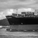 Navio porta-contêineres atracado no Porto de Santos, em imagem em preto e branco.