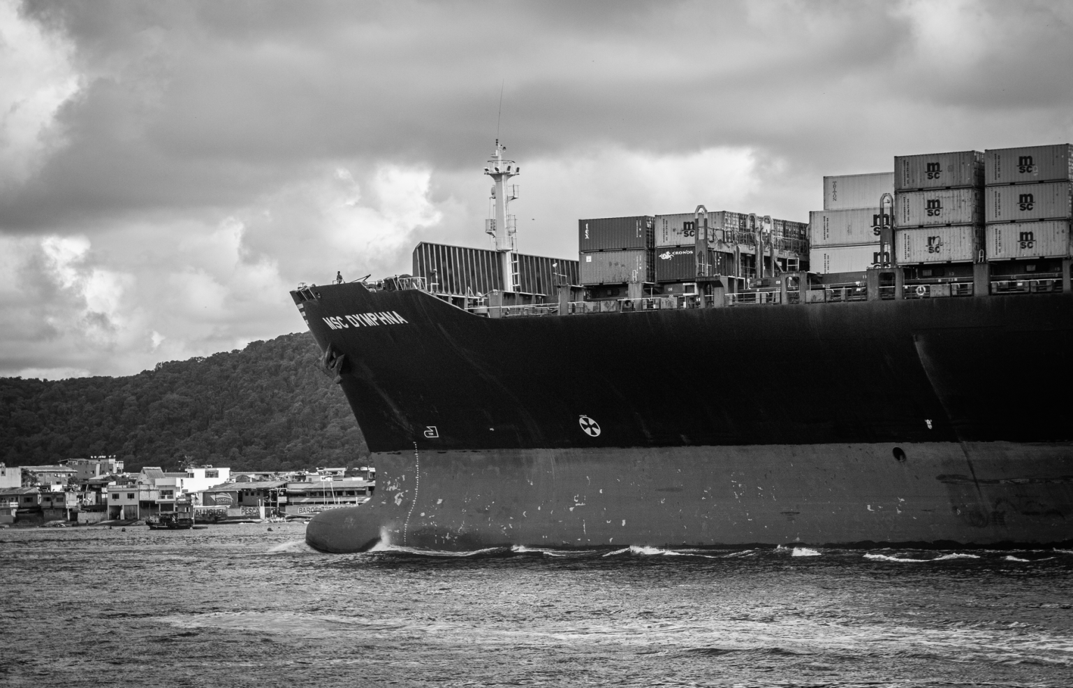 Navio porta-contêineres atracado no Porto de Santos, em imagem em preto e branco.