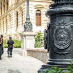 Dois agentes de segurança caminham diante de um edifício histórico em São Paulo.